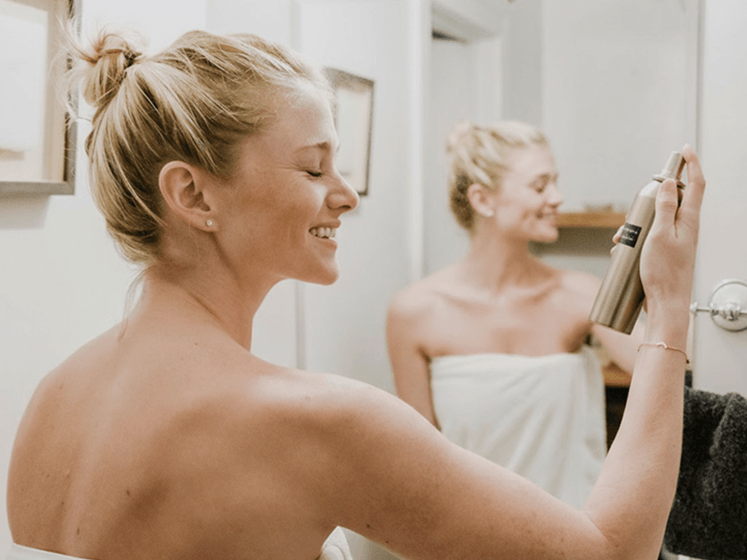 woman in the bathroom using a cosmetic product